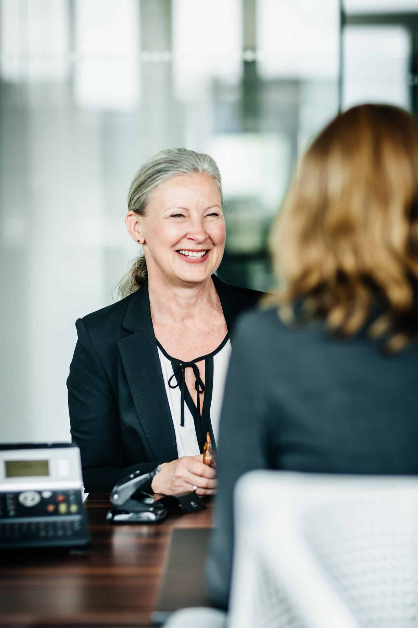 Mature Business Manager Smiling Talking To Colleague